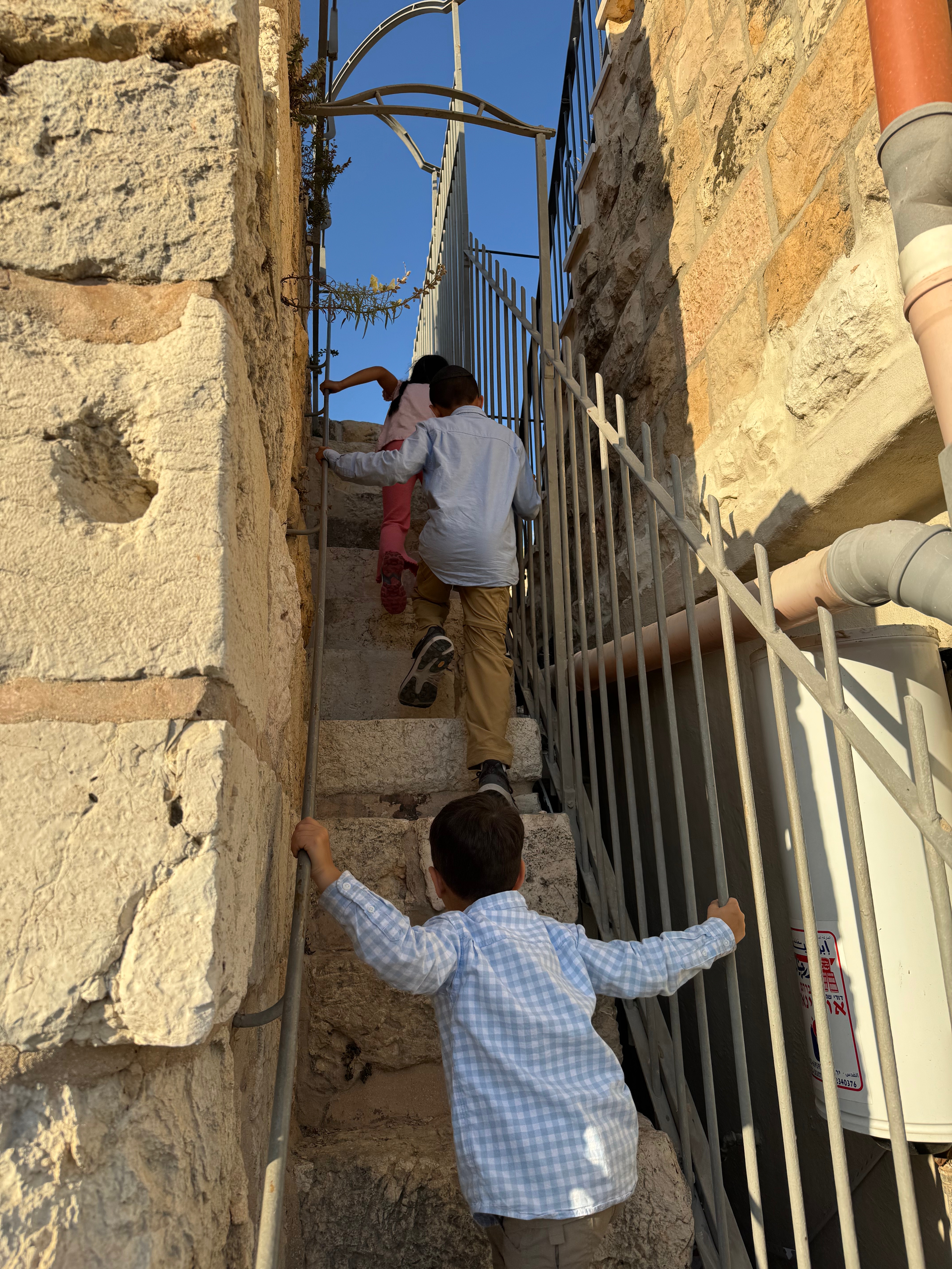 Children climbing a set of stone stairs on the wall of Old City Jerusalem